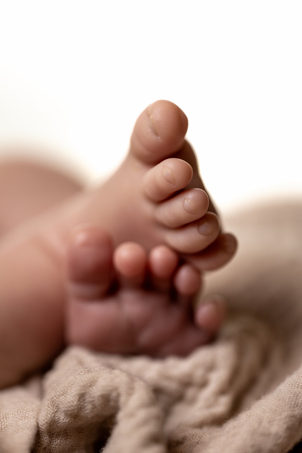 A newborn's feet on a soft knit blanket